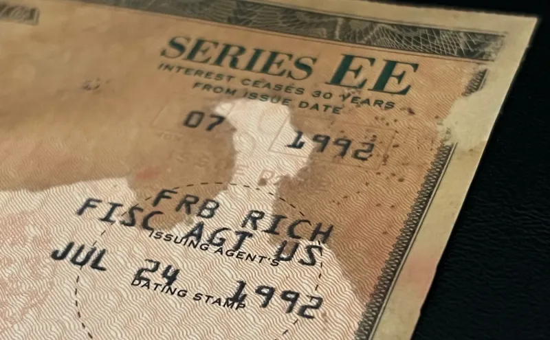 Close-up of a paper-based U.S. Treasury Savings Bond, showing water damage.
